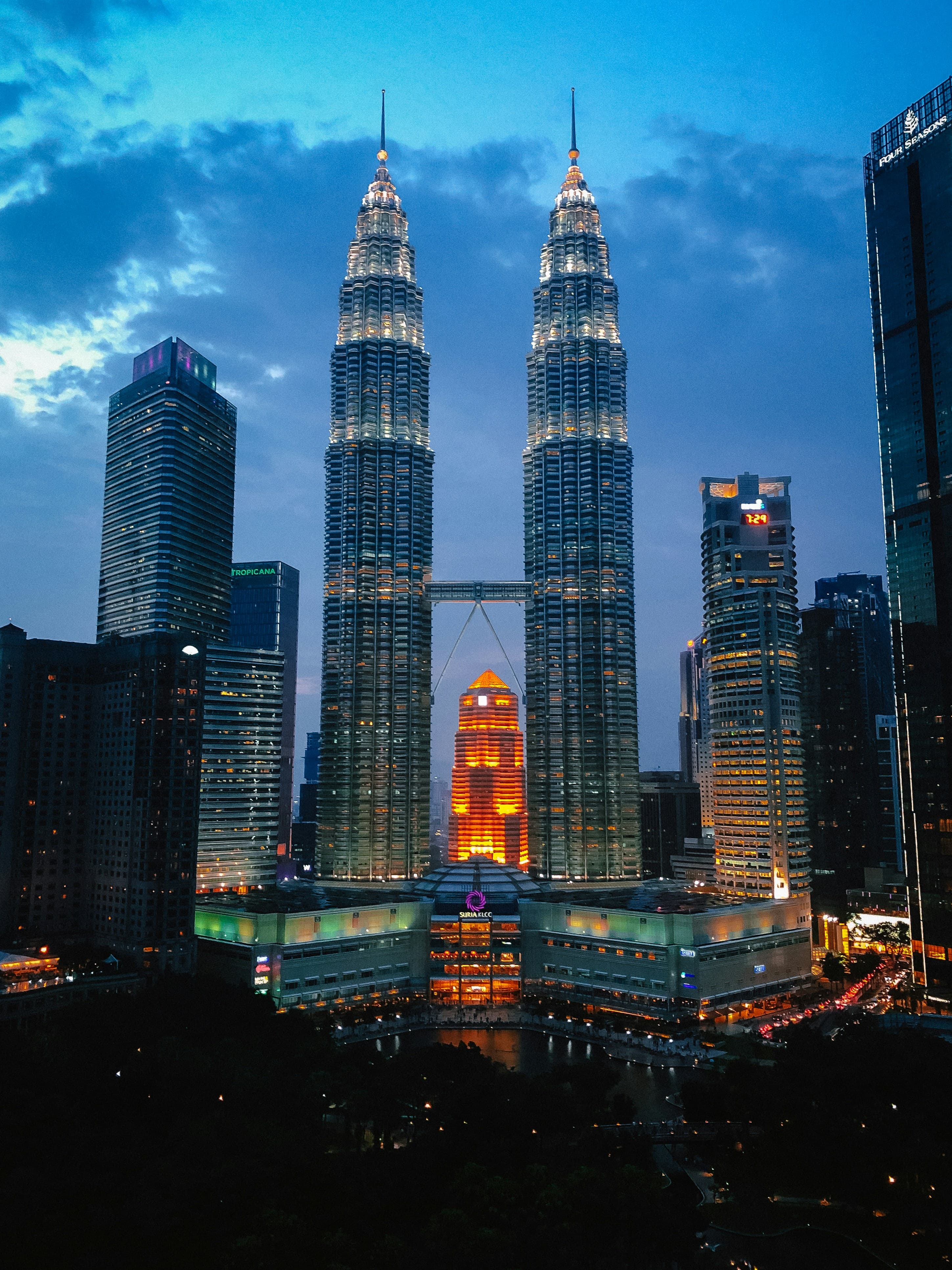 Kuala Lumpur city skyline at dusk with Petronas Twin Towers and modern skyscrapers